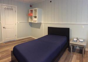 a bedroom with a blue bed and a table at 6B Best Location, 4 bedrm, 2 bathrm Beach Block in Seaside Heights