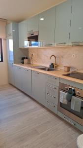 a large kitchen with white cabinets and a sink at The Market Square House in Faro