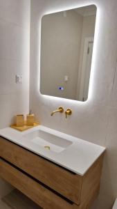 a bathroom with a white sink and a mirror at The Market Square House in Faro