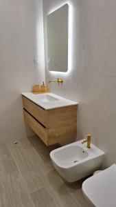 a bathroom with a sink and a toilet and a mirror at The Market Square House in Faro