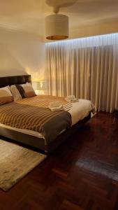 a bedroom with a large bed with a large window at The Market Square House in Faro +30 photos