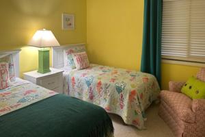 ein Schlafzimmer mit 2 Betten, einer Lampe und einem Stuhl in der Unterkunft Island Beach & Racquet Club G206 in Atlantic Beach