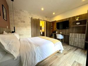 een slaapkamer met een wit bed en een keuken bij Loft Chianti en Val'Quirico in Santeagueda