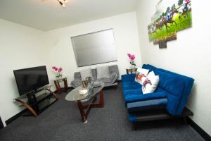 a living room with a blue couch and a tv at Vintage Elegance - Condo Steps Away from Casino in Hot Springs
