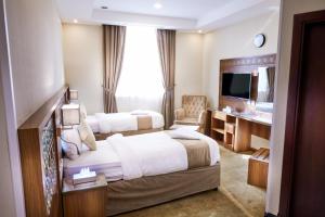 a hotel room with two beds and a television at فندق منار التوحيد 2 in Makkah