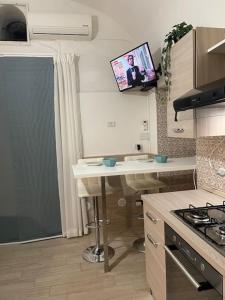 una cucina con tavolo e TV a parete di Monolocale a 200 mt stazione a Napoli