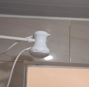 ein weißes Licht an einer Decke mit einer Leitung in der Unterkunft Casa das Embaúbas 5 in São José