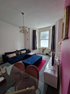 a living room with a blue couch and a table at Lovely One Bed Apartment in St Leonards in St. Leonards