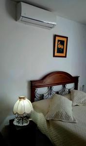 a bedroom with a bed with a lamp on a table at Monoambiente Vintage Las Palmas in Santa Cruz de la Sierra