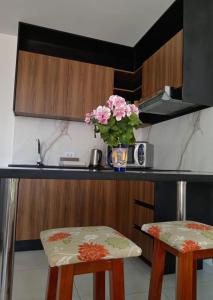 eine Küche mit 2 Stühlen und eine Vase mit rosa Blumen in der Unterkunft Monoambiente Vintage Las Palmas in Santa Cruz de la Sierra