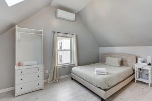 a white bedroom with a bed and a window at Coastal Lynn Escape with Fireplace 3 Mi to Beaches in Lynn