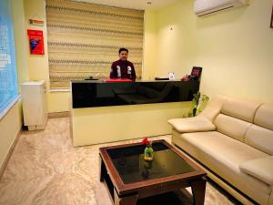 a man sitting at a counter in a living room at Hotel GOOD LUCK HOUSE For Family and International Guests Near Delhi Airport in New Delhi