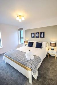 1 dormitorio con 1 cama blanca grande con almohadas azules en City Views by the Castle, Free Designated Parking., en Stirling
