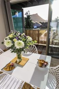 Una mesa blanca con un jarrón de flores. en City Views by the Castle, Free Designated Parking., en Stirling