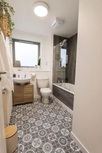Un baño con inodoro, lavabo y bañera. en City Views by the Castle, Free Designated Parking., en Stirling