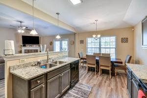 a kitchen with a sink and a dining room with a table at Prattville Home with Fire Pit - 2 Mi to Downtown! in Prattville