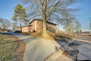 una casa con un albero sul lato di una strada di St Ann Townhome Less Than 1 Mi to International Airport! a Edmundson