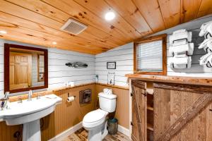 a bathroom with a toilet and a sink in a cabin at Lovely Maine Cabin with Deck, Gas Grill and Fire Pit! in Casco +16 photos