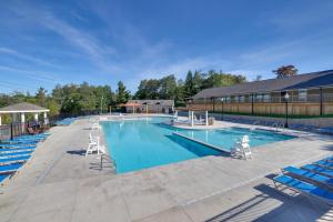 Game Room and Pool Access Pocono Paradise Haven في Tobyhanna: مسبح كبير وكراسي زرقاء ومبنى