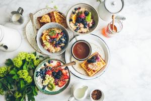 a table with four plates of breakfast food on it at Hotel GOOD LUCK HOUSE Near Delhi Airport in New Delhi