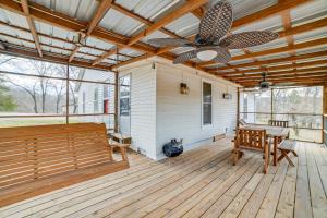 un portico con panchina e ventilatore a soffitto di Peaceful Cottage with Yard 2 Mi to Kentucky Lake! 