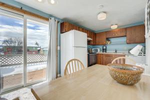 cocina con mesa y nevera blanca en Dog-Friendly Montana Home with Deck and Fenced-In Yard en Dillon