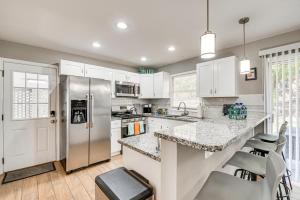a kitchen with white cabinets and a stainless steel refrigerator at Atlanta Home with Movie Projector and Basketball Hoop! in Atlanta