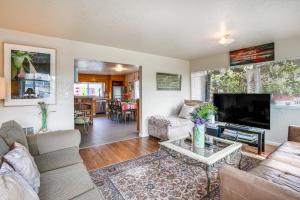 a living room with couches and a flat screen tv at Pet-Friendly Apartment 1 Mi to Lake Merritt! in Oakland