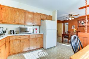 uma cozinha com armários de madeira e um frigorífico branco em Milwaukee Home with Fire Pit about 8 Mi to Lake Michigan em Milwaukee