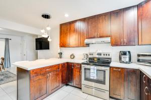 a kitchen with wooden cabinets and a stove at Pet-Friendly Ewa Beach Apartment about 1 Mi to Ocean! in Kapolei