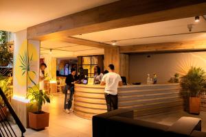a group of people standing at a bar in a restaurant at Hotel Natural Medellin in Medellín