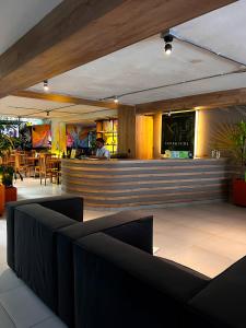 a bar in a restaurant with a man in the background at Green Hotel Medellin in Medellín