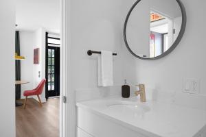 a white bathroom with a sink and a mirror at Norblad Hotel in Astoria, Oregon