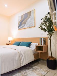 a bedroom with a bed and a potted tree at Luxury Studio Suite at The Gallery in Accra