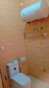 een badkamer met een toilet in een houten muur bij Timba Miché03 in Cotonou