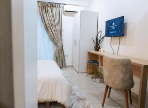 a bedroom with a desk and a chair and a bed at Luxury Studio Suite at The Gallery in Accra