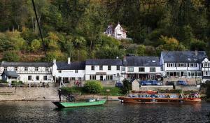 two boats are docked in the water next to houses at The Snuggle in Symonds Yat