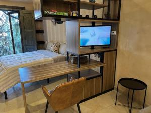 1 dormitorio con 1 cama y escritorio con TV en Loft Loreto en Val'Quirico, en Santeagueda