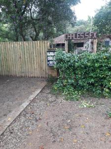 a wooden fence with a sign in front of a building at Chalés SFX in São Francisco Xavier