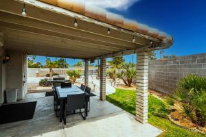 a patio with a table and chairs under a pergola at Vegas Getaway, Pool, Basket Ball, Games, Cook in Las Vegas