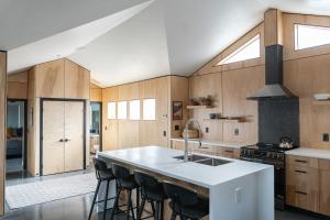 a kitchen with wooden cabinets and a kitchen island with bar stools at Tour de Fruita & EV charge point in Fruita