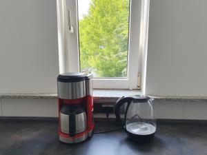 una cafetera y un jarrón sobre una mesa con una ventana en Privatzimmer direkt an der Uniklinik Mainz, en Mainz