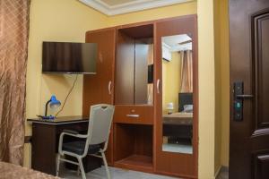 Habitación con escritorio y cama con espejo. en STEPMENS GUEST HOUSE en Botianaw
