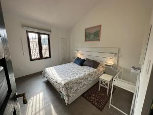 a bedroom with a bed and a table and window at Loft Edoardo en Val'Quirico in Santeagueda