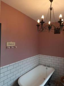 a bathroom with a bath tub and a chandelier at Salisbury Guest House - Free Parking in York