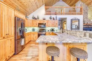 una gran cocina con armarios de madera y una gran isla en Spacious Pinetop Cabin with Private Yard and Hot Tub!, en Indian Pine