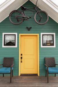 a bike hanging from a house with a yellow door at Tour de Fruita & EV charge point in Fruita
