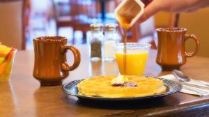 a person is pouring syrup onto a plate of waffles at Sedona Real Inn & Suites in Sedona