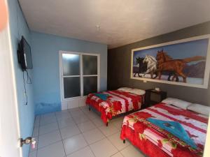 a bedroom with two beds and a window at CASA EMILY in San Pedro La Laguna