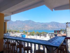 a balcony with chairs and a view of the water at CASA EMILY in San Pedro La Laguna